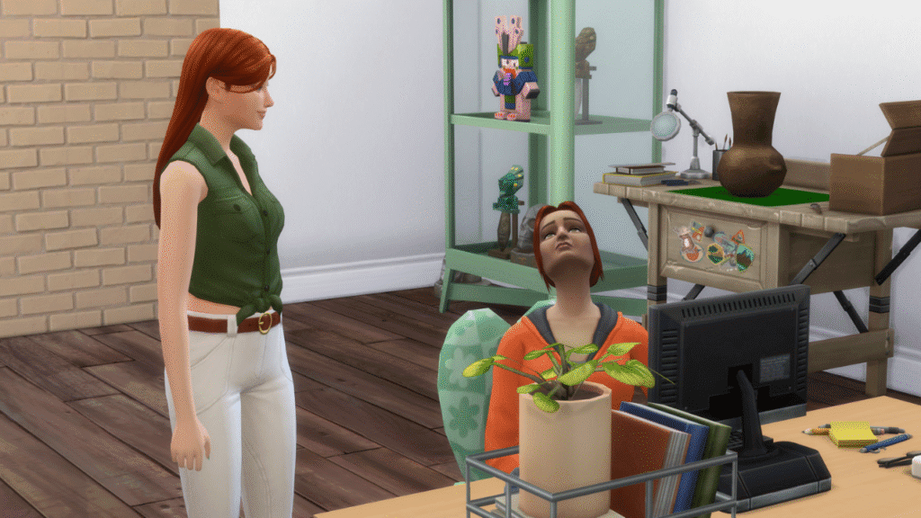 A screenshot from The Sims 4 showing two sims, one is standing and talking and the other is sitting at a desk being talked to.