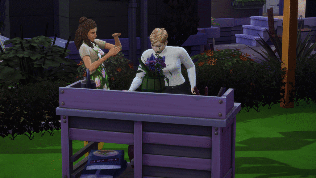 A screenshot from The Sims 4 showing two sims standing at a flower arranging table, one mentoring the other.