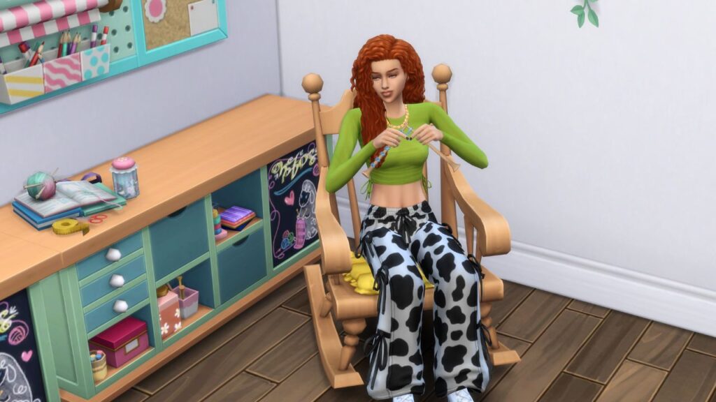 A screenshot from The Sims 4 showing a sim knitting in a rocking chair
