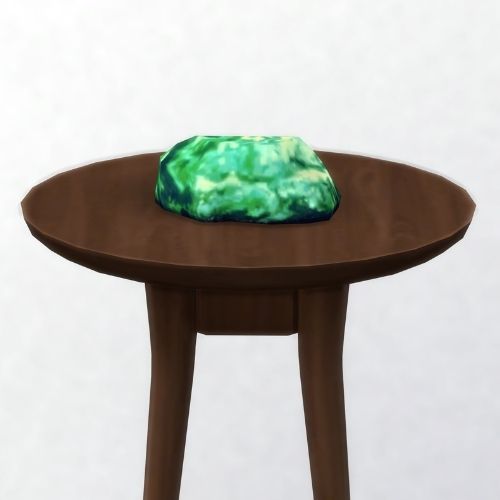 A screenshot from The Sims 4 showing a brown wooden table with simtanium on top