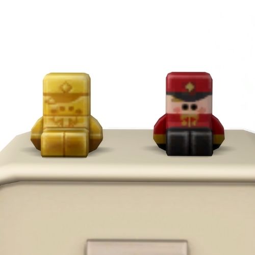 A screenshot from the sims 4 the top of a table with two Simmies on top. The one is gold and the other is a regular buddy simmi