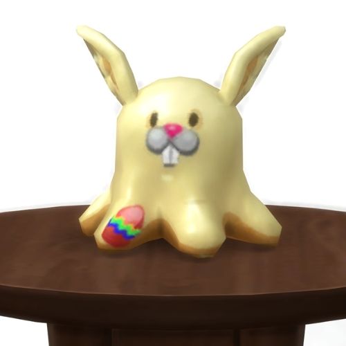 A screenshot from The Sims 4 showing a round, brown table with a Meduso Plushie on top that's dressed like a bunny