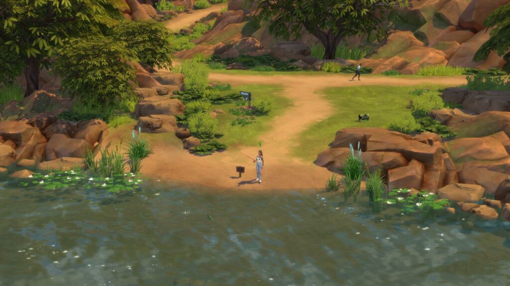 A screenshot from The Sims 4 showing a sim fishing at the end of a path near rocks