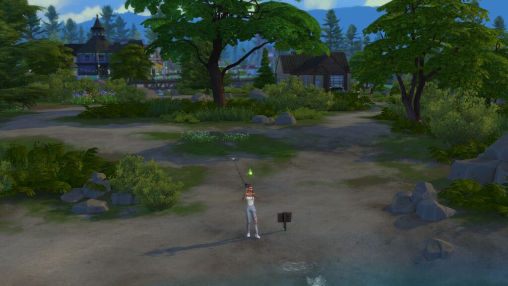 A screenshot from The Sims 4 showing a sim fishing on a beach in front of a small house