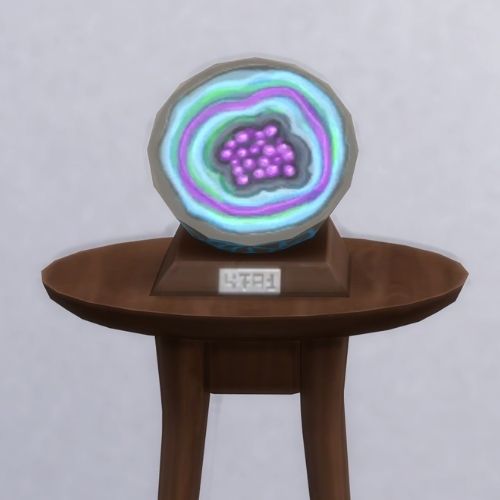 A screenshot from The Sims 4 with a brown table and on top is the geode named Corbut