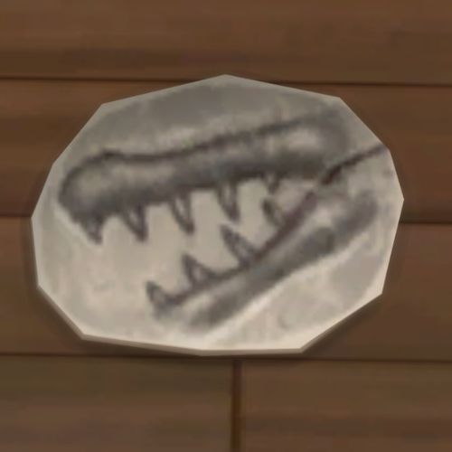 A screenshot from The Sims 4 showing a rock on the ground. On the rock is an image of a crocodile jaw