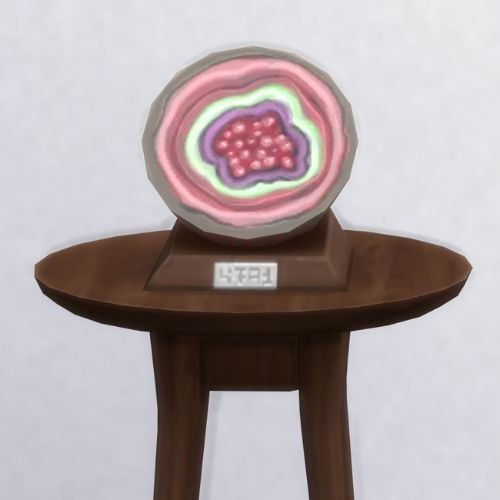 A screenshot from The Sims 4 with a brown table and on top is the geode named Eye of the Stormbore