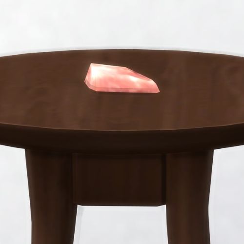 A screenshot from The Sims 4 showing a brown wooden table with flamingonium on top