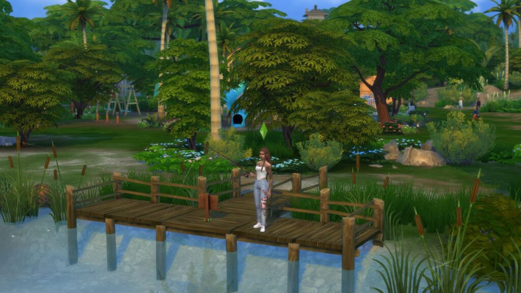 A screenshot from The Sims 4 showing a sim fishing at a dock in front of a kid's park