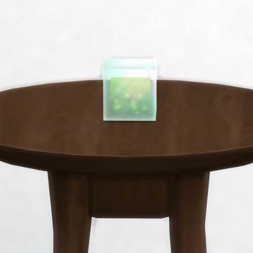 A screenshot from The Sims 4 showing a dark brown table with a Goobleck in a square on top