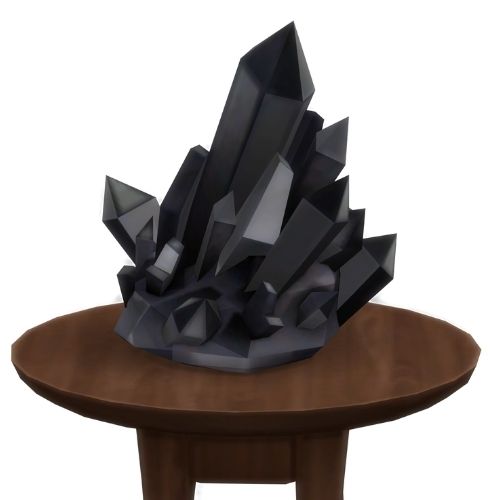 A screenshot from The Sims 4 showing a brown circular table with a crystal on top. This image has a crystal called jet