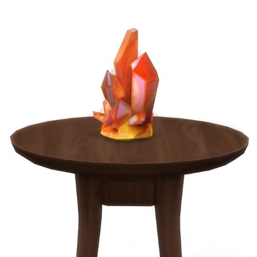 A screenshot from The Sims 4 showing a brown circular table with a crystal on top. This image has a crystal called orange topaz