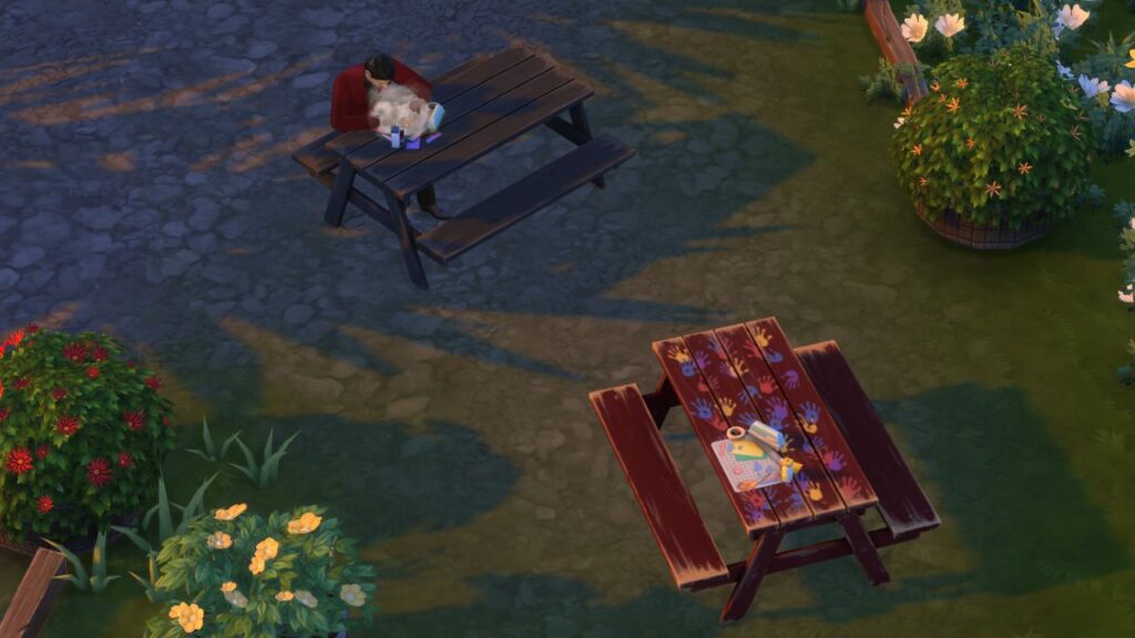 A screenshot from The Sims 4 showing the location of paper crafting kits in a park 