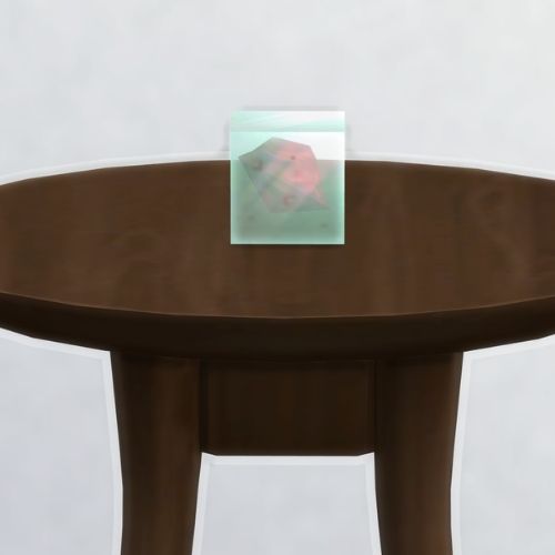 A screenshot from The Sims 4 showing a dark brown table with a Peryllium element in a square on top
