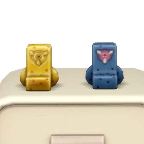 A screenshot from the sims 4 the top of a table with two Simmies on top. The one is gold and the other is a regular pit beast Simmi