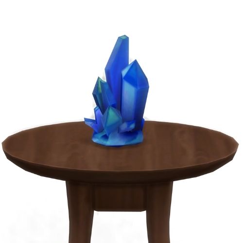 A screenshot from The Sims 4 showing a brown circular table with a crystal on top. This image has a crystal called sapphire