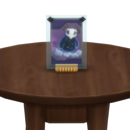 A screenshot from The Sims 4 showing a brown table with a Voidcritter on top. This has the voidcritter named veild
