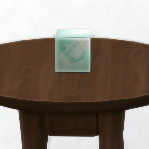 A screenshot from The Sims 4 showing a dark brown table with a Wolfium element in a square on top