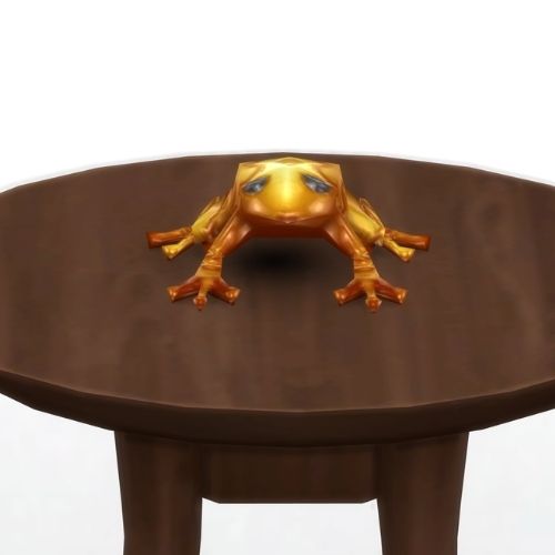 A screenshot from The Sims 4 showing a brown circle table and on top is a golden frog with black eyes